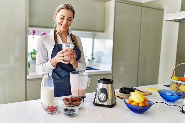 Genç Sarışın Kadın Gülümsüyor Mutfakta Buzlu Içecek Bardağı Tutuyor — Stok fotoğraf