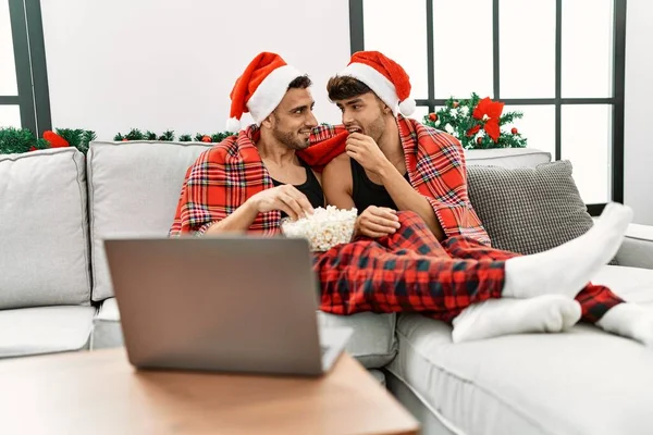二つのヒスパニック男性カップル見ますムービー座っていますクリスマス装飾によって家 — ストック写真