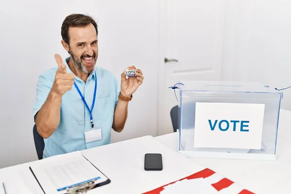 Middle Age Man Beard Sitting Ballot Holding Vote Badge Pointing — Zdjęcie stockowe