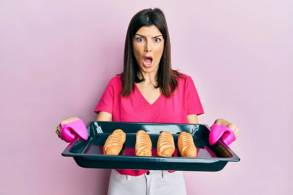 Young Hispanic Woman Holding Homemade Bread Afraid Shocked Surprise Amazed — Stock Photo, Image