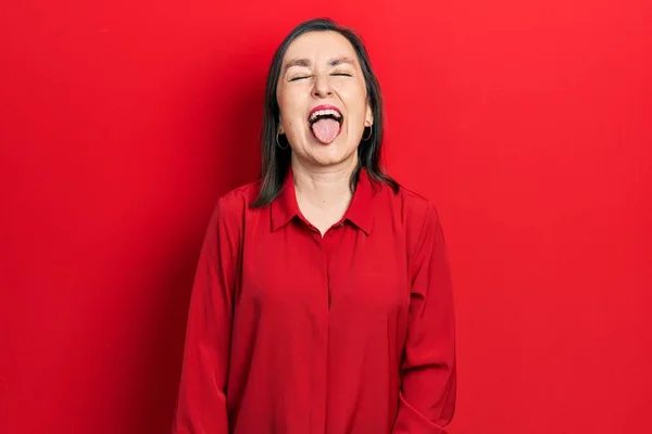 変な表情で嬉しそうに舌を突き出しているカジュアルな服を着た中年のヒスパニック系女性 感情の概念 — ストック写真