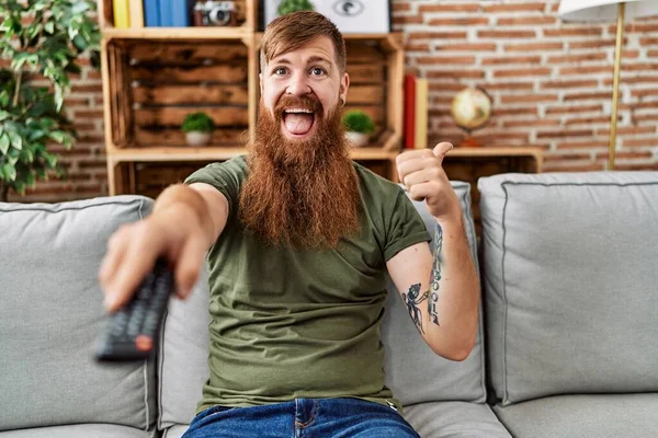 Redhead Man Long Beard Holding Television Remote Control Pointing Thumb — Stock fotografie