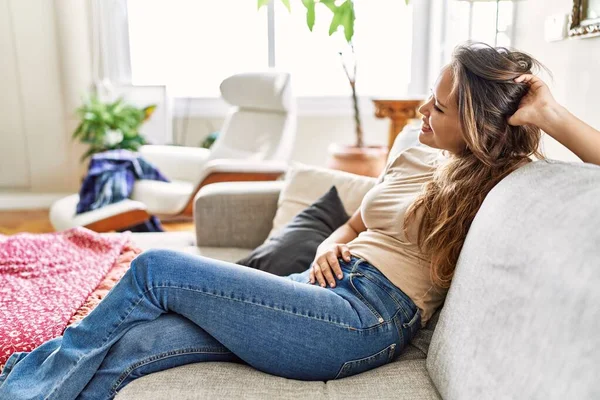 Joven Chica Hispana Sonriendo Feliz Sentada Sofá Casa —  Fotos de Stock