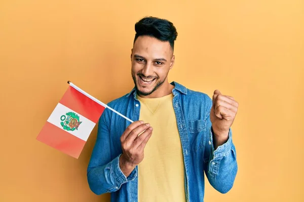 Young Arab Man Holding Peru Flag Screaming Proud Celebrating Victory — стоковое фото