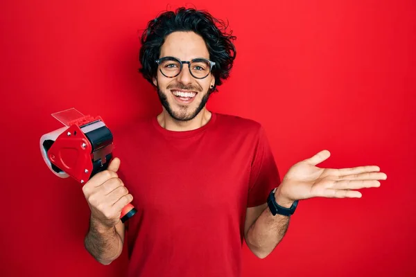 Handsome Hispanic Man Holding Packing Tape Celebrating Achievement Happy Smile — Stockfoto