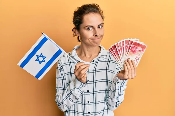 Junge Brünette Frau Mit Israel Flagge Und Schekel Banknoten Skeptisch — Stockfoto