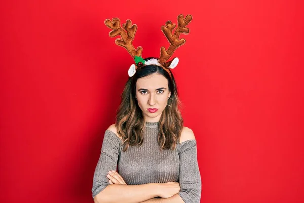 Young Hispanic Girl Wearing Deer Christmas Hat Skeptic Nervous Disapproving — стоковое фото