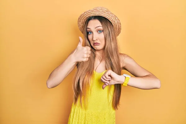 Young Blonde Girl Wearing Summer Hat Doing Thumbs Disagreement Agreement — Stockfoto