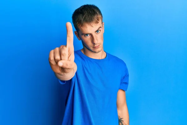 Sıradan Mavi Tişört Giyen Genç Beyaz Bir Adam Parmağını Kaldırmış — Stok fotoğraf