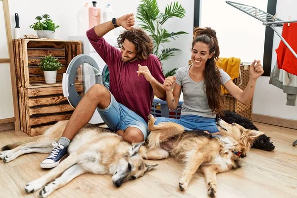 Young Hispanic Couple Doing Laundry Dogs Dancing Happy Cheerful Smiling — Stockfoto