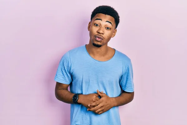 Joven Hombre Afroamericano Vistiendo Casual Camiseta Azul Mirando Cámara Soplando —  Fotos de Stock