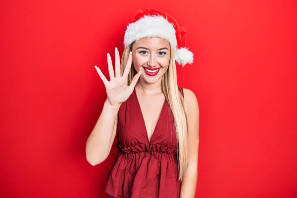 Молода Блондинка Різдвяному Капелюсі Показує Вказує Пальцями Номер Ять Посміхаючись — стокове фото
