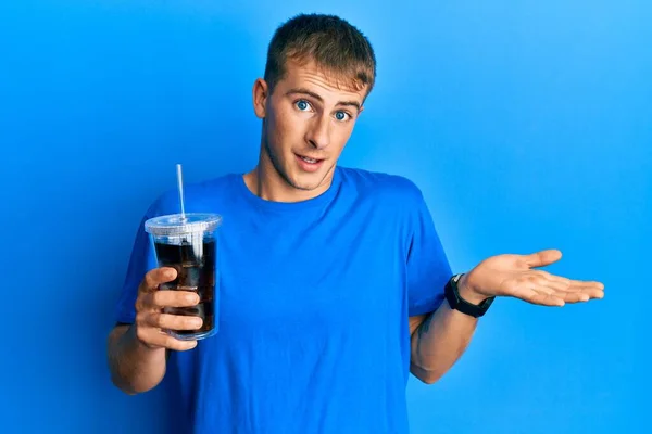 幸せな笑顔で達成を祝うソーダ飲料の若い白人男性飲料手を上げと勝者の式 — ストック写真