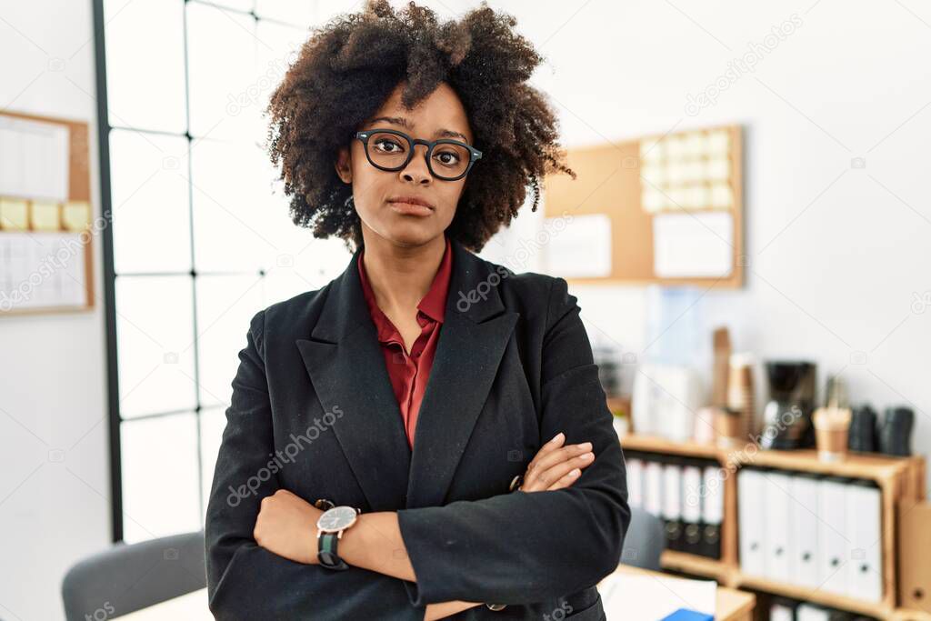 Young african american woman standing with arms crossed gesture at office