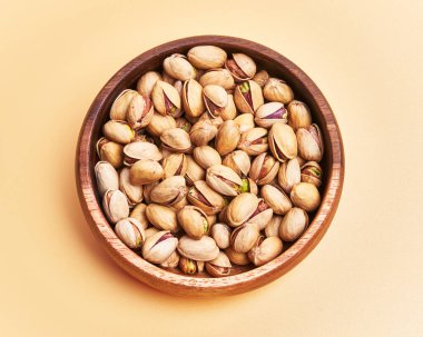  Sarı arka planda bir kase fıstık.