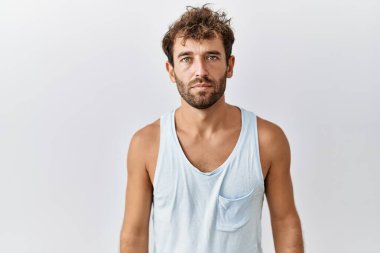 Soyutlanmış arka planda duran yakışıklı genç adam yüzünde ciddi bir ifadeyle rahatlamış. Basit ve doğal bir şekilde kameraya bakıyorsun.. 