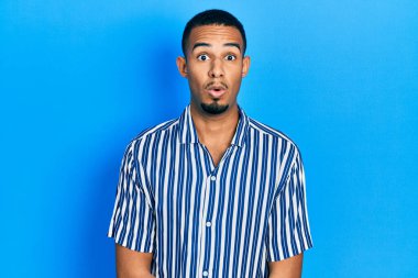 Genç Afro-Amerikan adam günlük kıyafetler giyiyor. Şaşırtıcı bir ifade, korku ve heyecan dolu bir yüz ifadesi var.. 