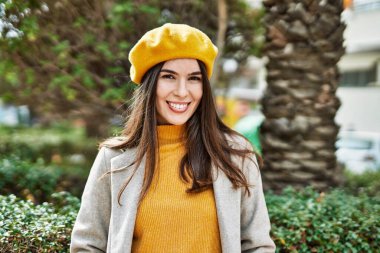 Genç İspanyol kız gülümseyerek şehirde mutlu mesut dikiliyor..