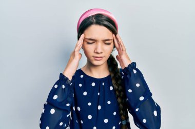 Young brunette girl wearing elegant look with hand on head for pain in head because stress. suffering migraine. 