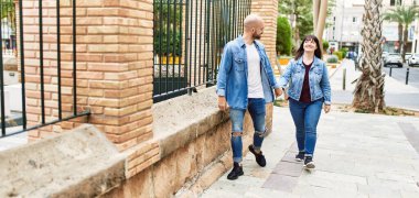 Genç İspanyol çift gülümseyerek mutlu mesut şehirde el ele yürüyorlar..