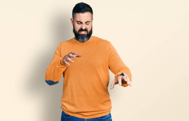 Sakallı İspanyol bir adam günlük kışlık süveter giyiyor. Tiksindirici tepki verdiği için rahatsız ve ürkek bir ifade takınıyor.. 