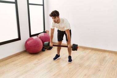 Spor merkezinde halterli genç bir İspanyol antrenman yapıyor.