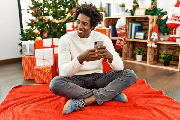 Hombre Afroamericano Joven Usando Teléfono Inteligente Sentado Suelo Por Árbol — Foto de Stock