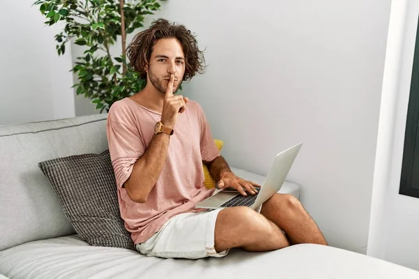Young Hispanic Man Sitting Sofa Home Using Laptop Asking Quiet — Stock Photo, Image