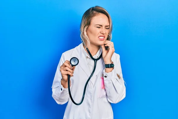 Beautiful Young Blonde Doctor Woman Holding Stethoscope Touching Mouth Hand — 스톡 사진