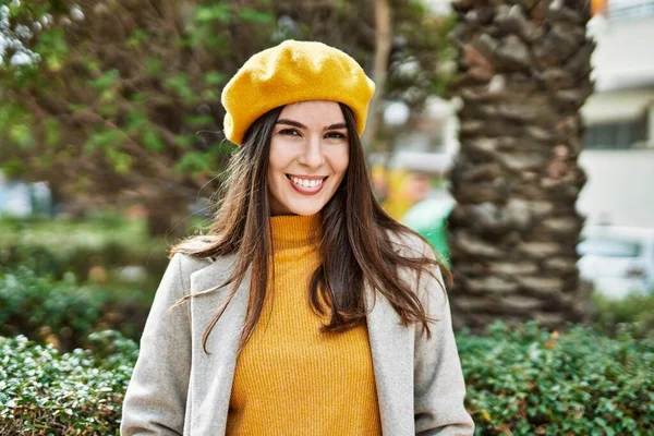 Genç İspanyol kız gülümseyerek şehirde mutlu mesut dikiliyor..