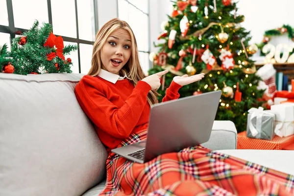 Young Caucasian Girl Using Laptop Sitting Sofa Christmas Tree Amazed — Φωτογραφία Αρχείου