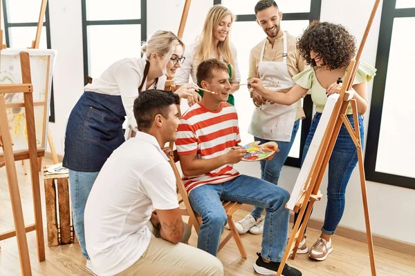 Mutlu gülümseyen ve ortak arayan bir grup insan sanat stüdyosunda..