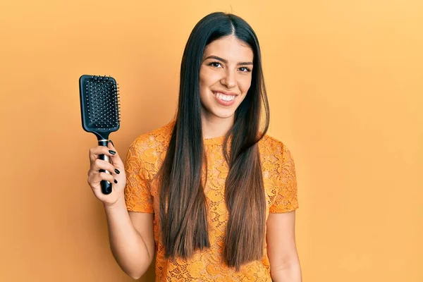 Young Hispanic Woman Holding Hairbrush Looking Positive Happy Standing Smiling — Zdjęcie stockowe