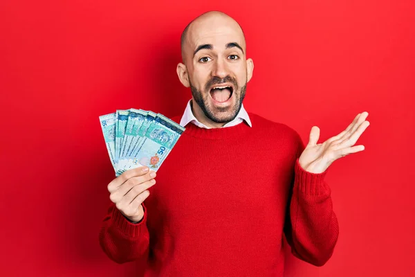 Młody Łysy Mężczyzna Trzymający Banknotów Ringgit Malezji Świętujących Osiągnięcie Szczęśliwym — Zdjęcie stockowe