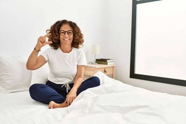 Middle Age Hispanic Woman Sitting Bed Home Smiling Confident Gesturing — Stockfoto