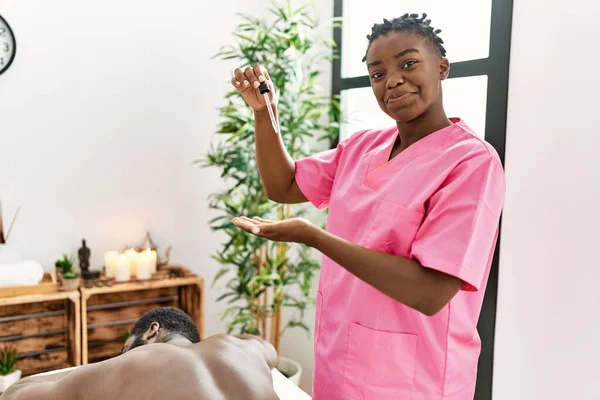 Young Physiotherapist Woman Smiling Happy Holding Oil Massage Clinic — Foto Stock