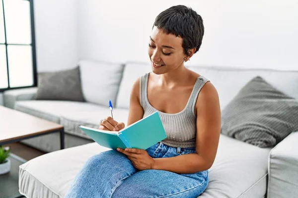 Joven Mujer Hispana Sonriendo Confiada Escritura Cuaderno Casa — Foto de Stock