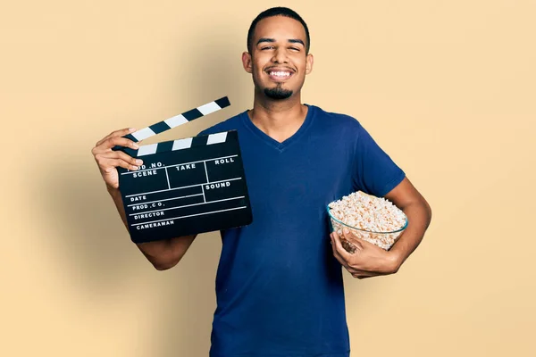 Young African American Man Eating Popcorn Holding Film Clapboard Smiling — Foto Stock
