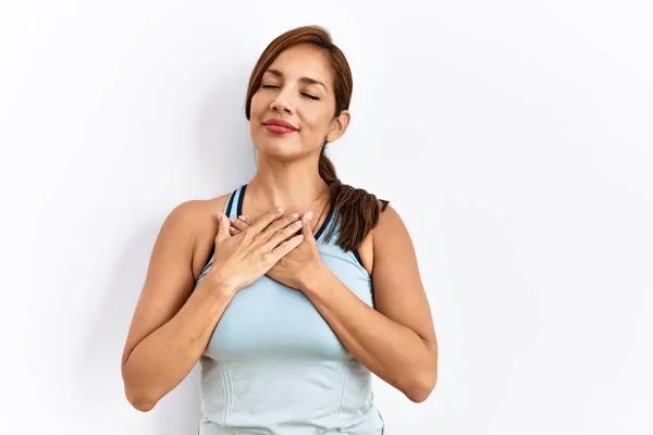 年轻的拉丁女人 身穿运动服 背景孤寂 双手放在胸前笑着 闭着眼睛 脸上挂着感激的手势 健康概念 — 图库照片