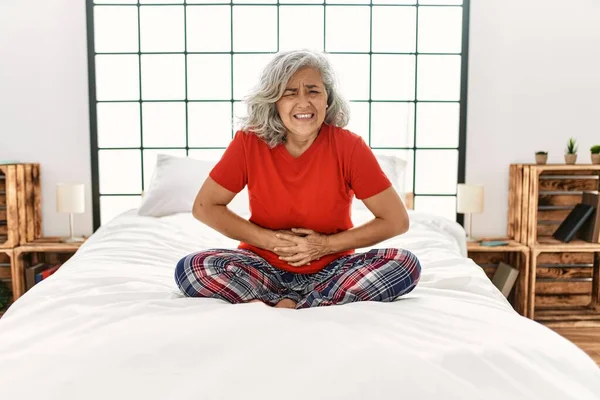 Жінка Середнього Віку Сірим Волоссям Сидить Ліжку Вдома Рукою Животі — стокове фото