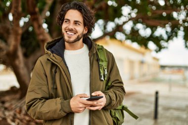 Şehirde akıllı telefon kullanan yakışıklı bir İspanyol.