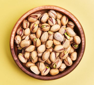  Sarı arka planda bir kase fıstık.