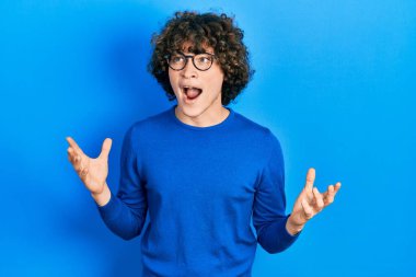 Yakışıklı, sıradan kıyafetler giyen, gözlüklü, deli gibi bağıran, sinirli ifadeli ve kollarını kaldırmış genç bir adam. hüsran kavramı. 