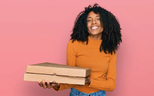 若いですアフリカ系アメリカ人の女の子を保持配達ピザボックス見て正と幸せな立ちと笑顔で自信を持って笑顔ショー歯 — ストック写真