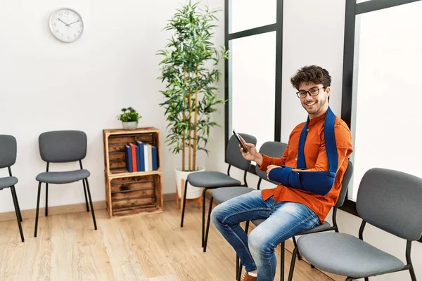 Ung Latinamerikansk Man Skadas Med Hjälp Smartphone Sitter Stol Kliniken — Stockfoto