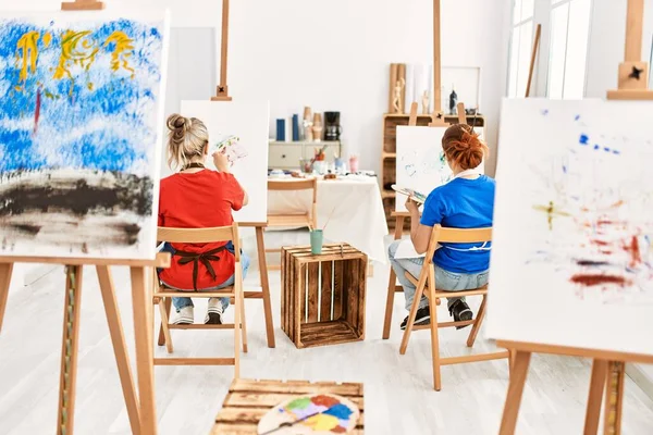 2人の芸術家の学生女性が美術学校で絵画を見る — ストック写真