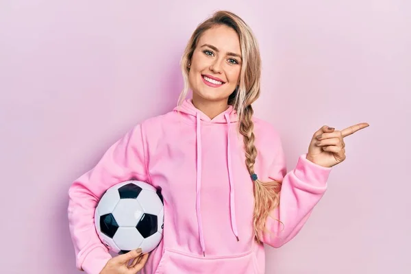 Beautiful Young Blonde Woman Holding Soccer Ball Smiling Happy Pointing — Stock Photo, Image