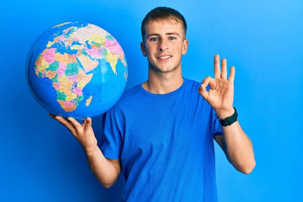 Ung Kaukasier Man Håller Världen Bollen Gör Tecken Med Fingrar — Stockfoto