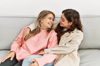 Genç ve güzel bir çift kanepede oturup sarılıyorlar..