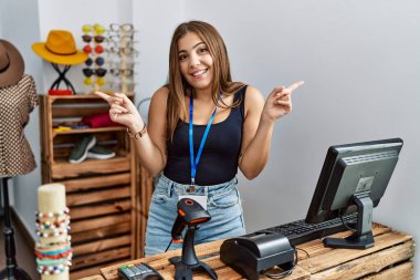 Perakende dükkanında açık mesajla afişi tutan esmer genç bir kadın farklı yönleri işaret ederek gülümsüyor. reklam için kopyalama alanı 